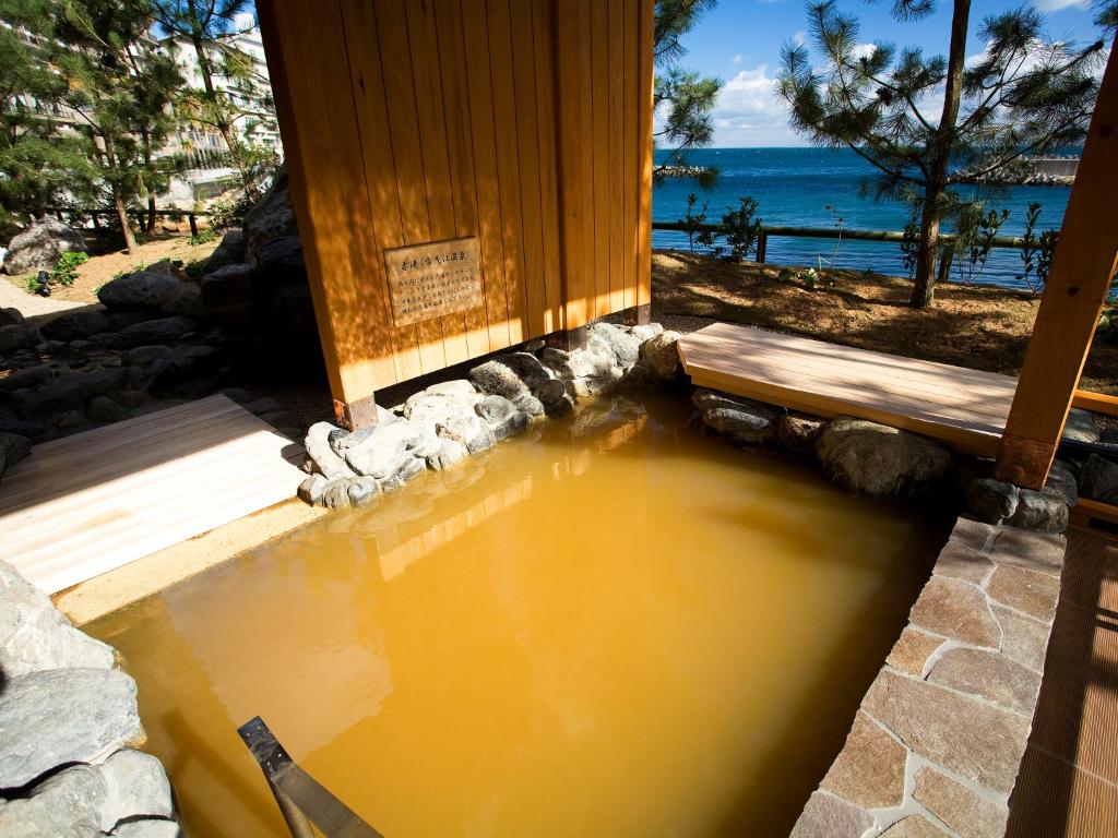 une piscine d'eau en face d'un bâtiment dans l'établissement Hotel New Awaji, à Sumoto