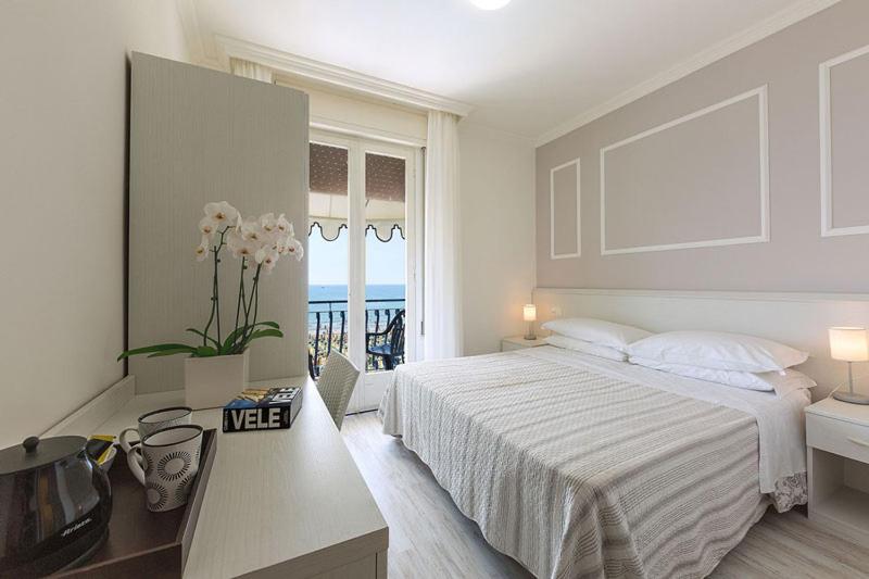 une chambre blanche avec un lit et une vue sur l'océan dans l'établissement Hotel Plaza Esplanade, à Lido di Jesolo