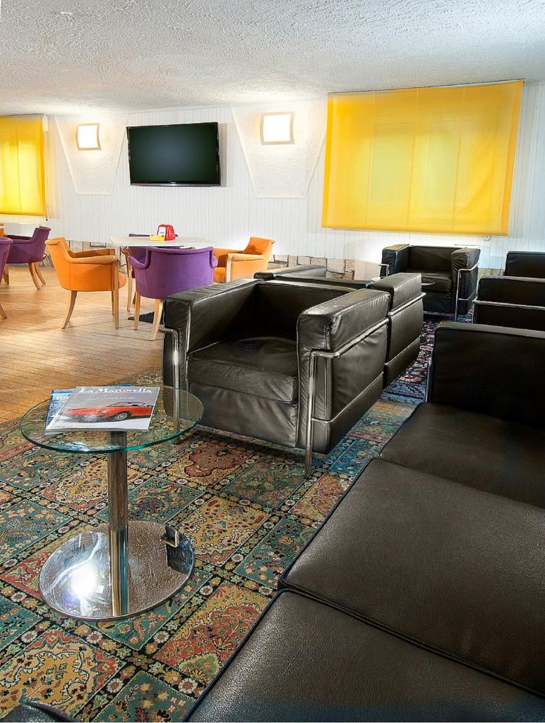 un salon avec un canapé en cuir et une table dans l'établissement Hotel St. Moritz, à Bellaria-Igea Marina