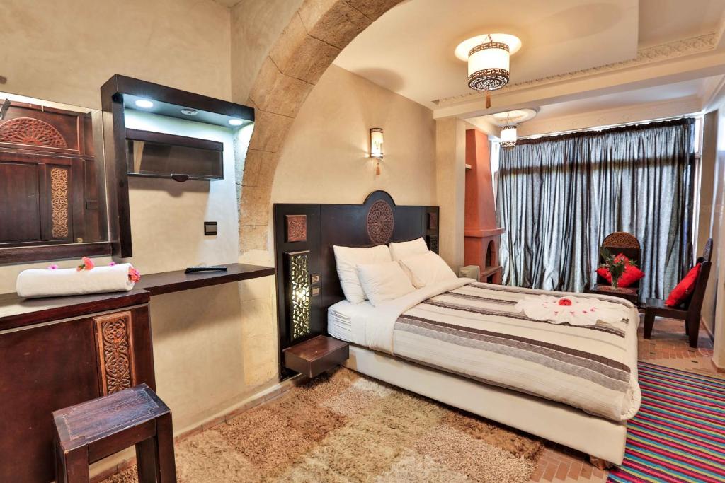 une chambre avec un grand lit dans une pièce dans l'établissement Riad Nakhla, à Essaouira