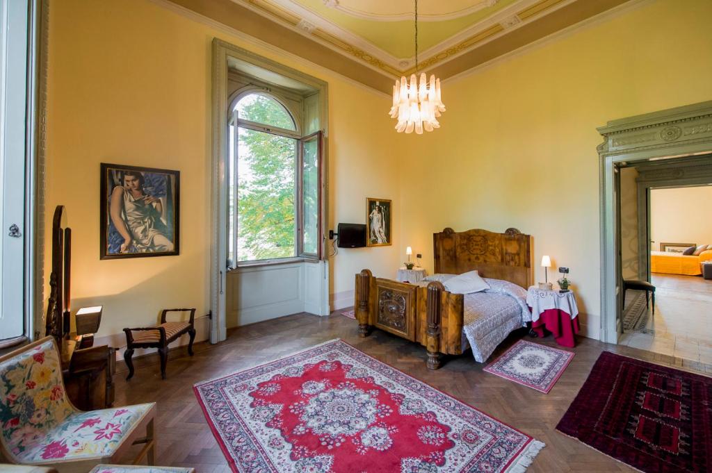 une chambre avec un lit et un lustre dans l'établissement Villa Confalonieri, à Mandello del Lario 14 autres photos