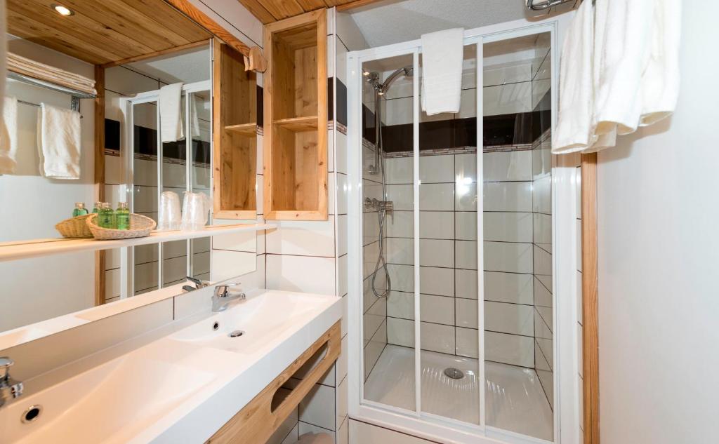 une salle de bain avec douche et lavabo dans l'établissement Logis Hôtel Spa la Cascade, à Ceillac 37 autres photos