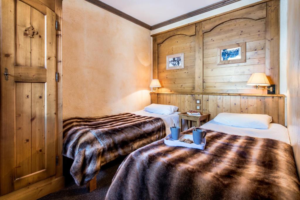 deux lits dans une chambre aux murs en bois dans l'établissement Résidences Village Montana by Les Etincelles, à Tignes
