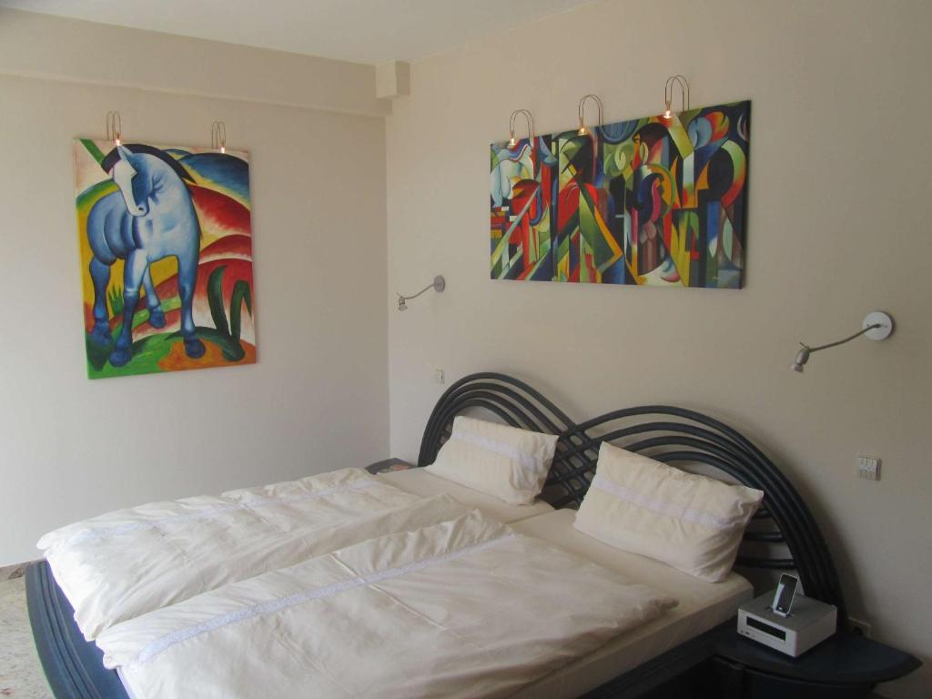 une chambre avec un lit avec un tableau sur le mur dans l'établissement Villa Camporosso, à Camporosso
