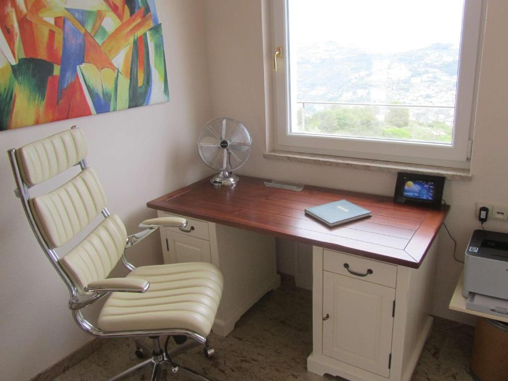 un bureau avec une chaise, un ventilateur et une fenêtre dans l'établissement Villa Camporosso, à Camporosso 44 autres photos