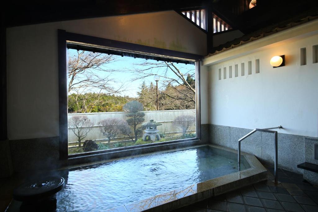 Cette chambre dispose d'une piscine avec une grande fenêtre. dans l'établissement Iwamura Sanso, à Ena