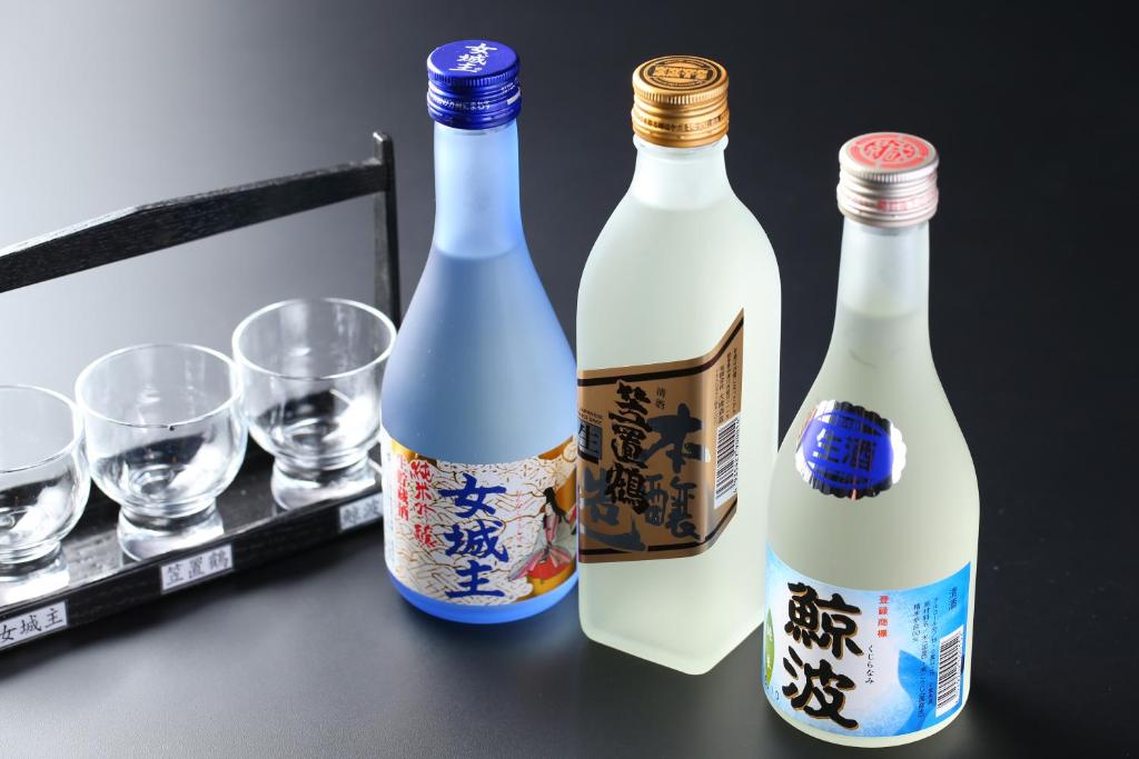 trois bouteilles de vin assises sur une table avec des verres dans l'établissement Iwamura Sanso, à Ena