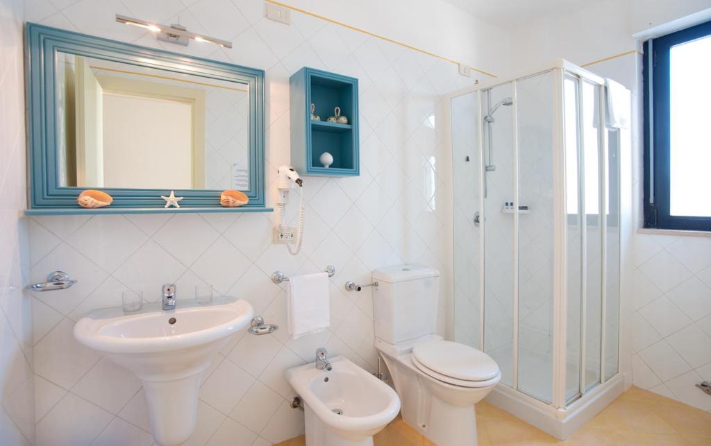 une salle de bain avec un lavabo, des toilettes et une douche dans l'établissement Hotel Del Levante, à Torre Canne
