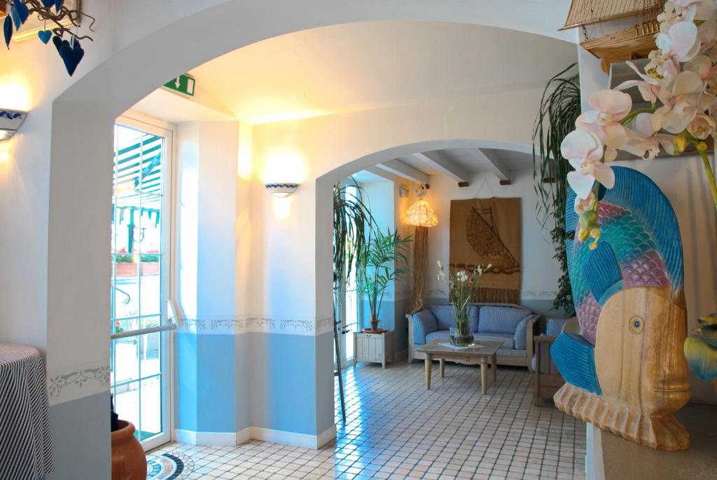 un couloir avec un salon avec un bleu et blanc dans l'établissement Hotel La Goletta, à Lignano Sabbiadoro