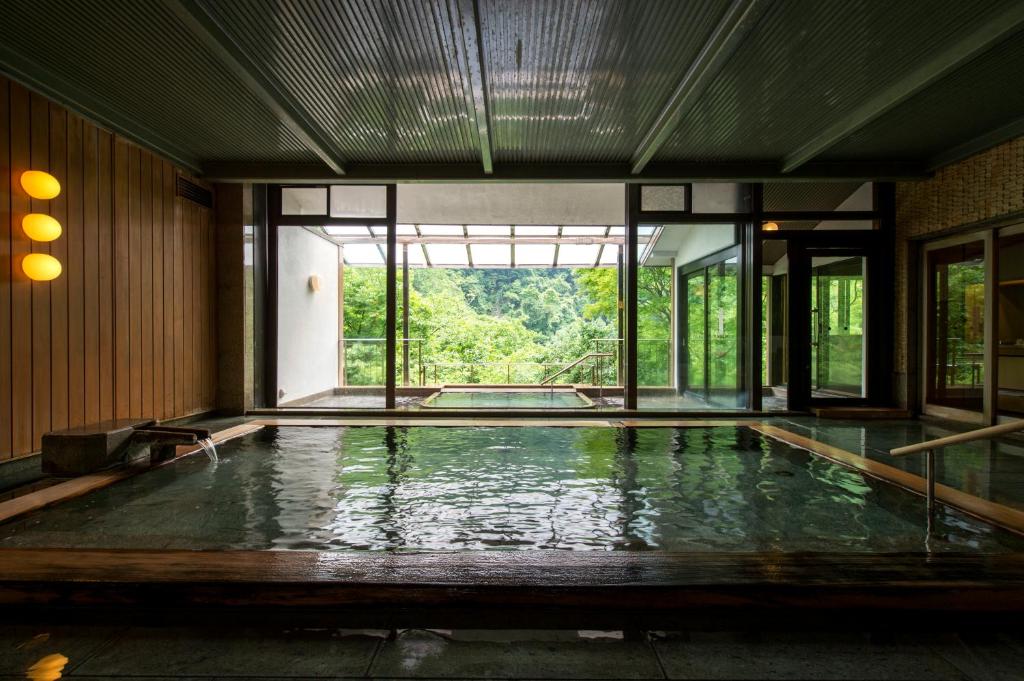 une piscine dans un immeuble avec une grande fenêtre dans l'établissement Fujiiso, à Takayama