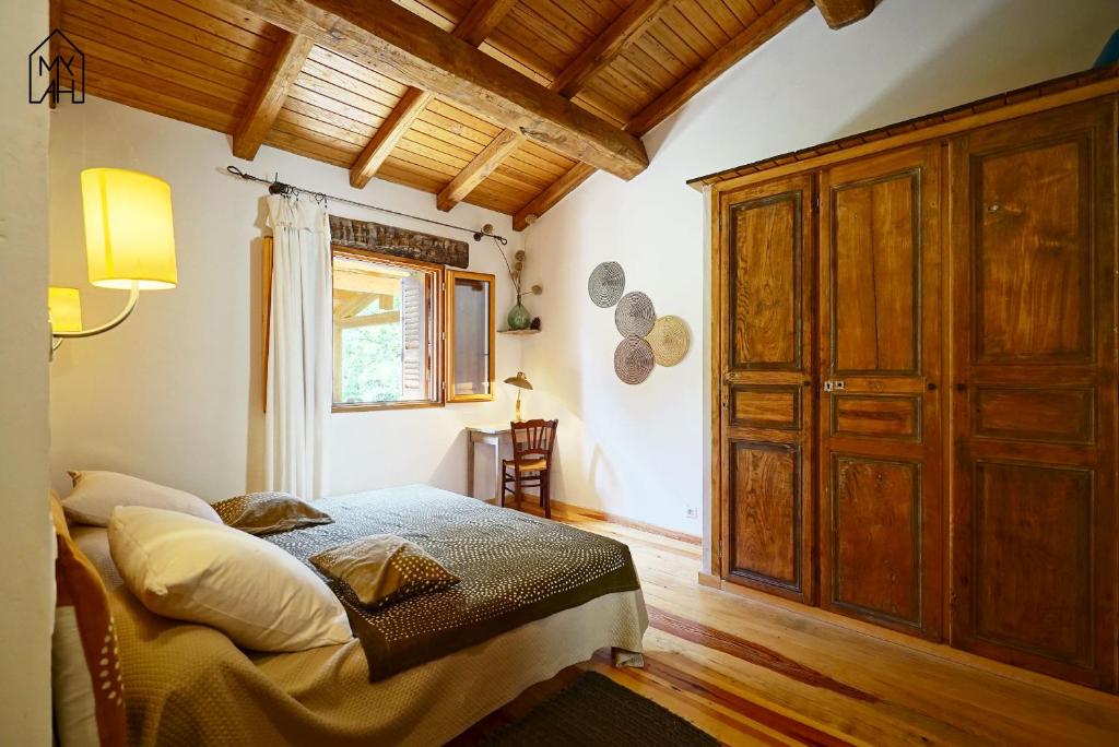 une chambre avec un lit et une armoire en bois dans l'établissement Les gites de Tasso, à Tasso