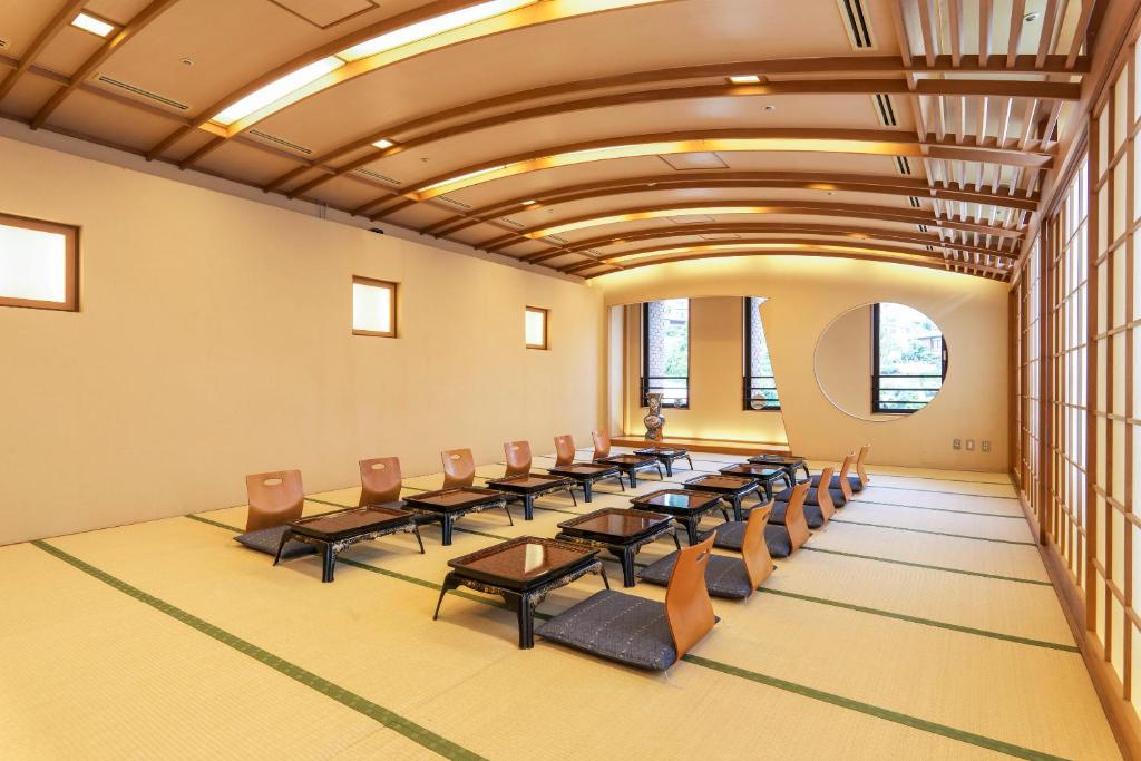 une salle de conférence avec des chaises, des tables et des fenêtres dans l'établissement New Welcity Yugawara, à Atami 37 autres photos