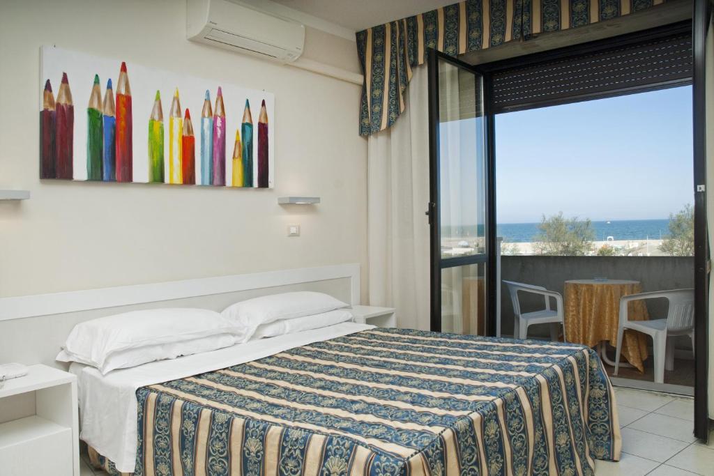 une chambre d'hôtel avec un lit et un balcon dans l'établissement Hotel Genzianella, à Cervia