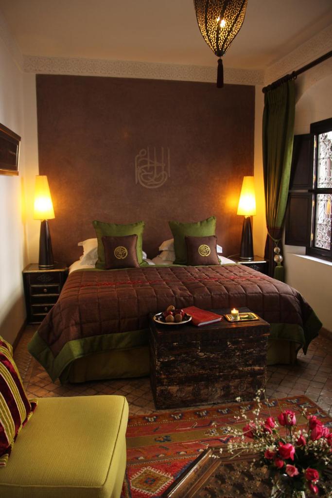 une chambre avec un grand lit et un canapé dans l'établissement Riad Assakina, à Marrakech