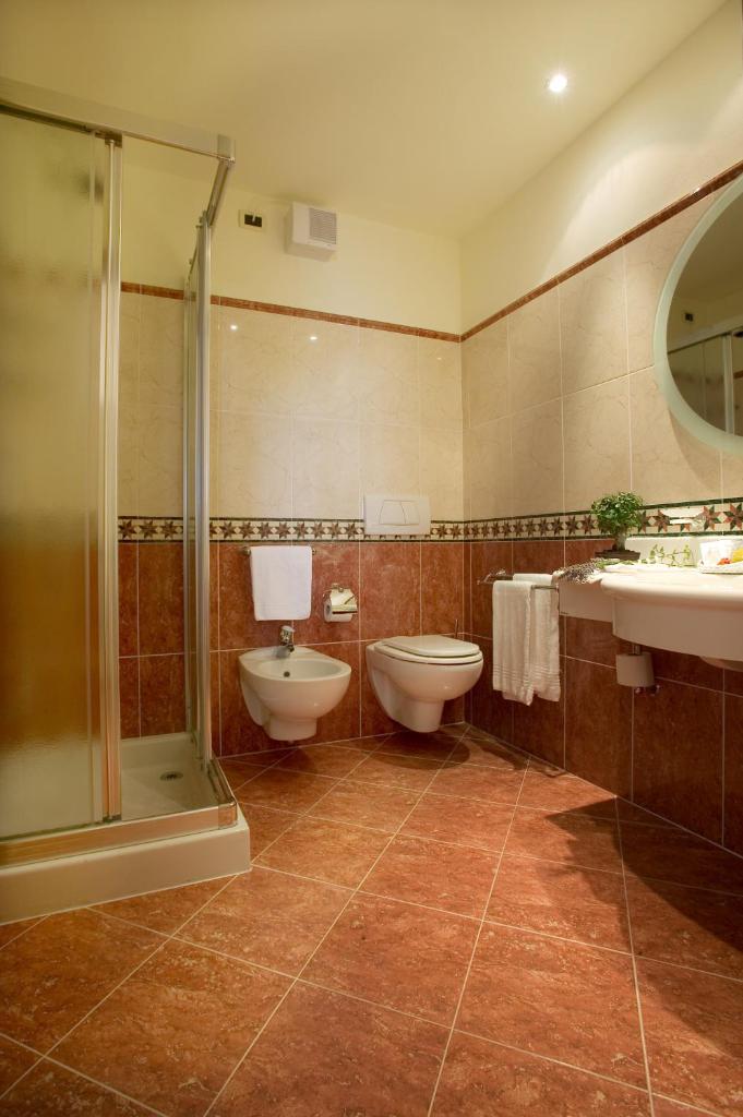 La salle de bains est pourvue de 2 toilettes, d'une douche et d'un lavabo. dans l'établissement Hotel La Rondine, à Sirmione