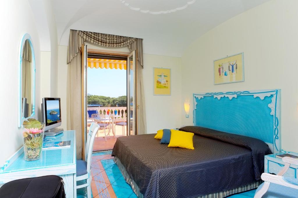 une chambre avec un lit bleu et un balcon dans l'établissement Hotel Bellevue Benessere & Relax, à Ischia