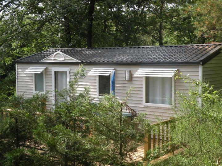 une petite maison blanche au milieu des arbres dans l'établissement Camping Hurongues, à Pomeys 26 autres photos