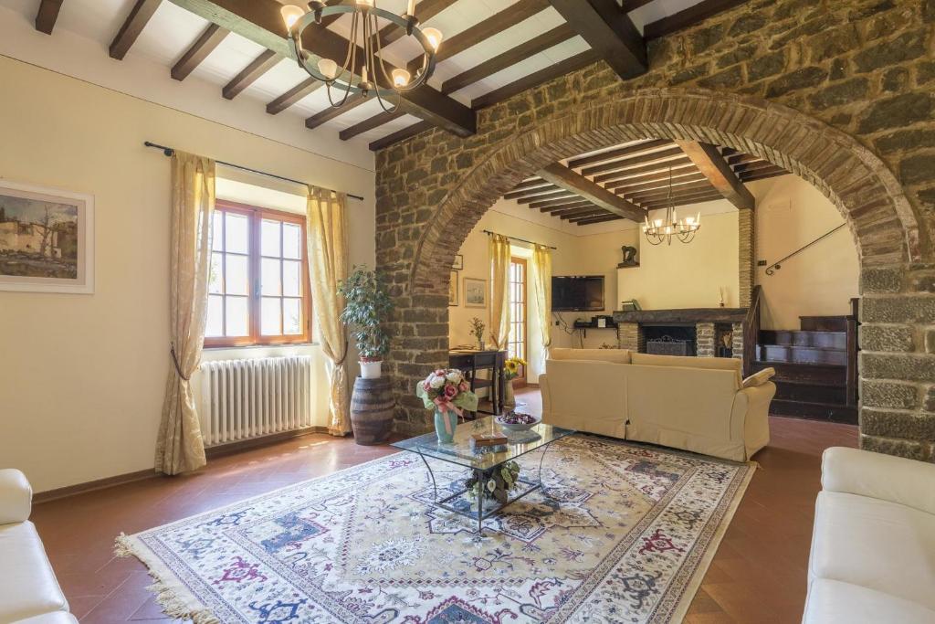 - un salon avec une table et un mur en briques dans l'établissement Villa ai Cedri, à Cortone