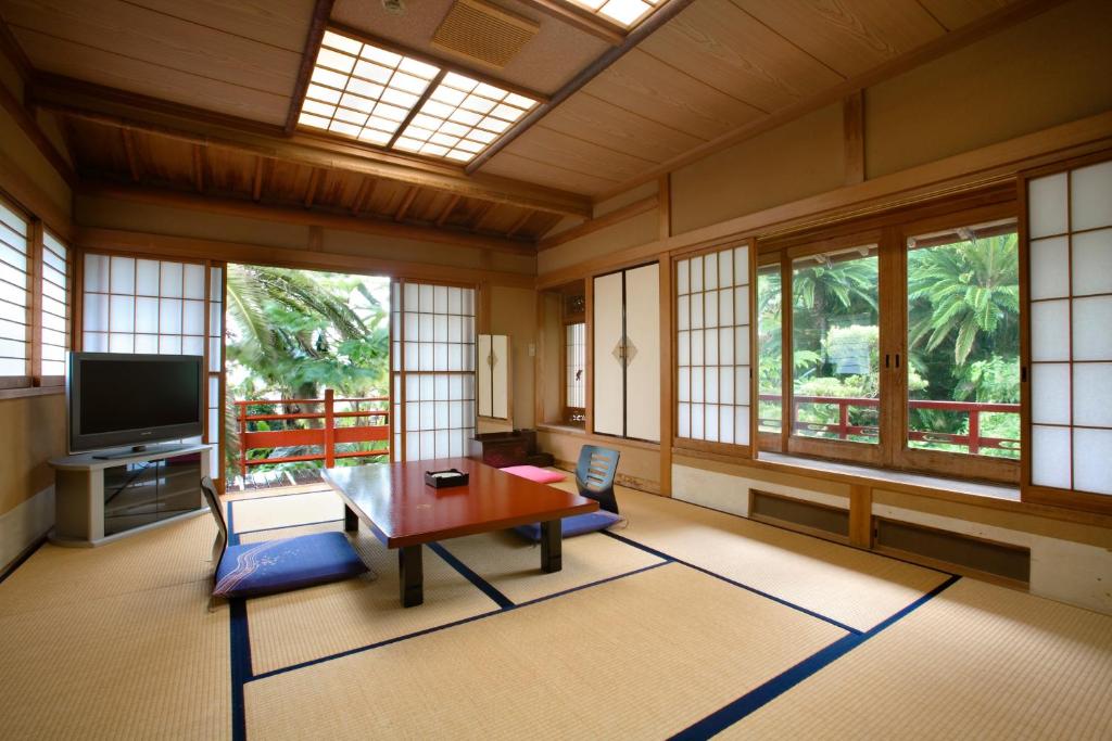 Cette chambre dispose d'une table, d'une télévision et de fenêtres. dans l'établissement Chikurakan, à Minamiboso