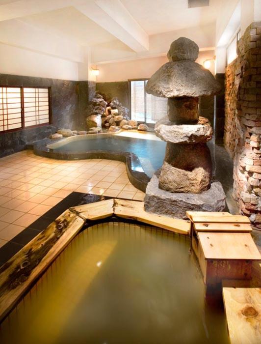 une grande salle de bains avec une baignoire et une fontaine dans l'établissement Chikurakan, à Minamiboso