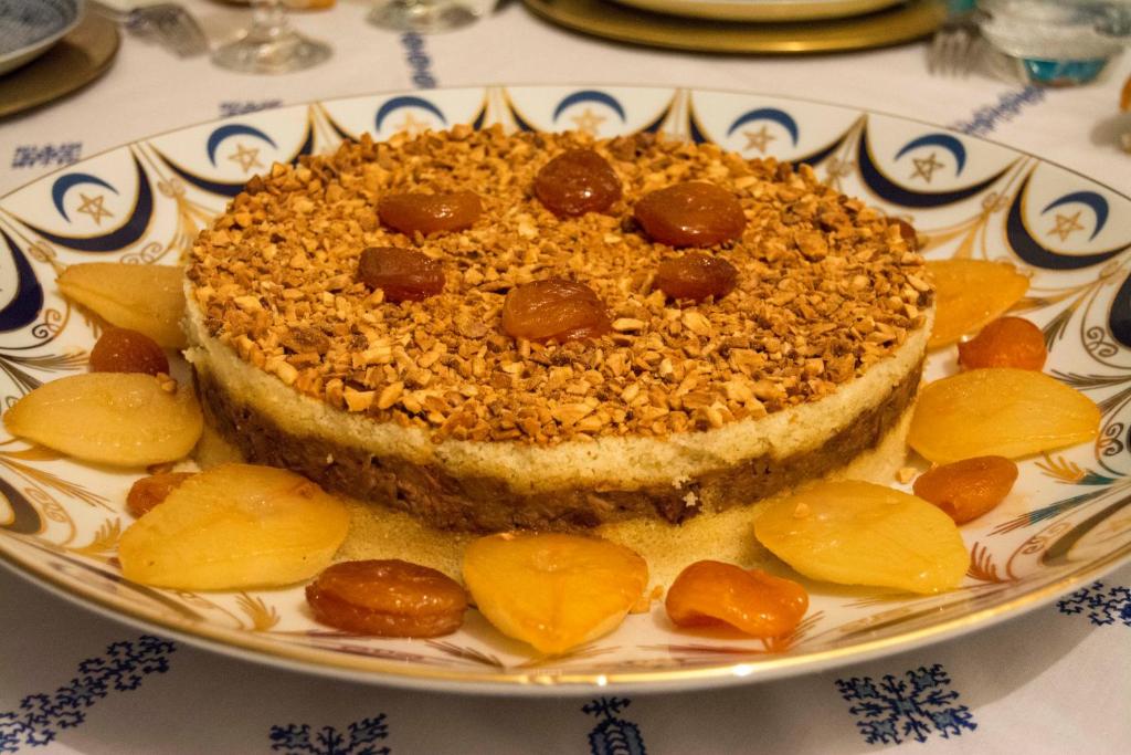 un morceau de gâteau sur une plaque avec des tranches de pêches dans l'établissement Riad Souafine, à Fès
