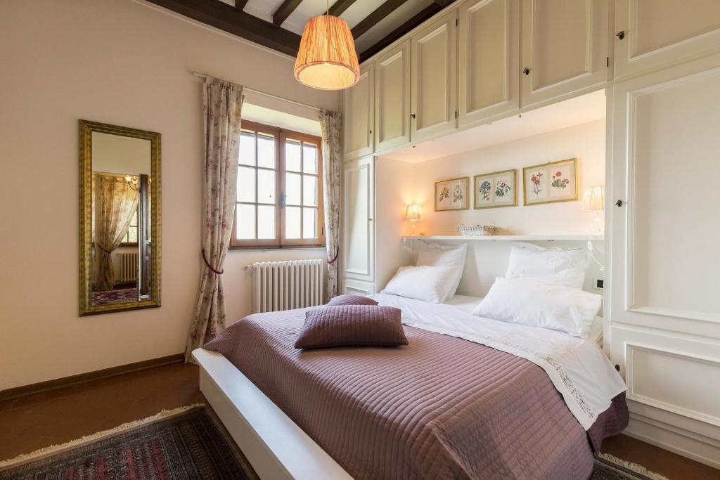 une chambre avec un lit, un miroir et une fenêtre dans l'établissement Villa ai Cedri, à Cortone