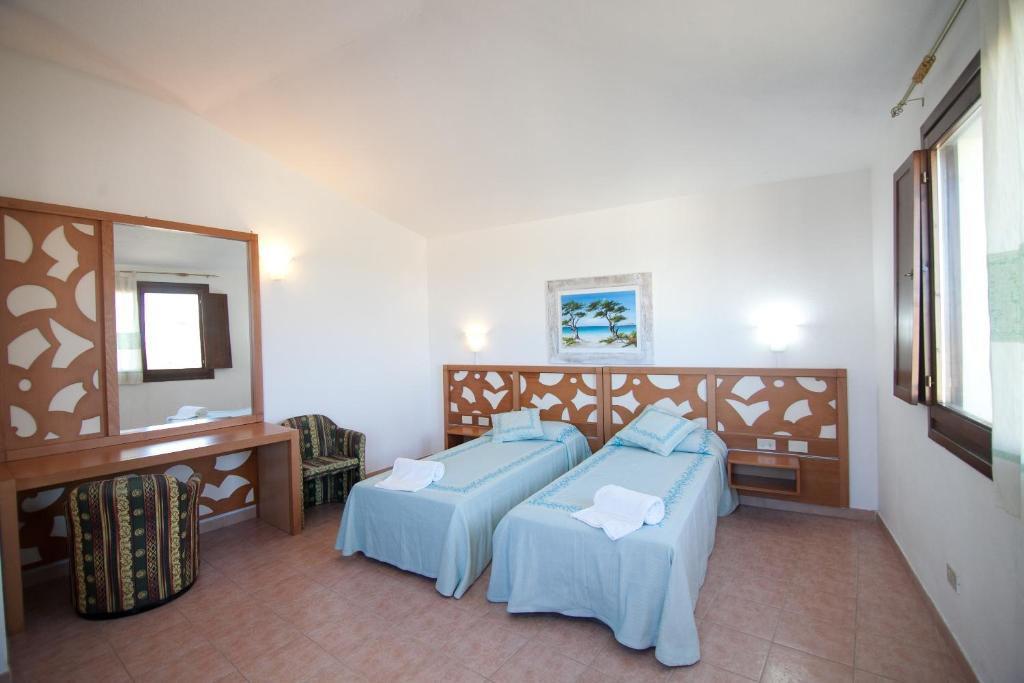 une chambre d'hôtel avec deux lits et un miroir dans l'établissement Club Esse Gallura, à Aglientu