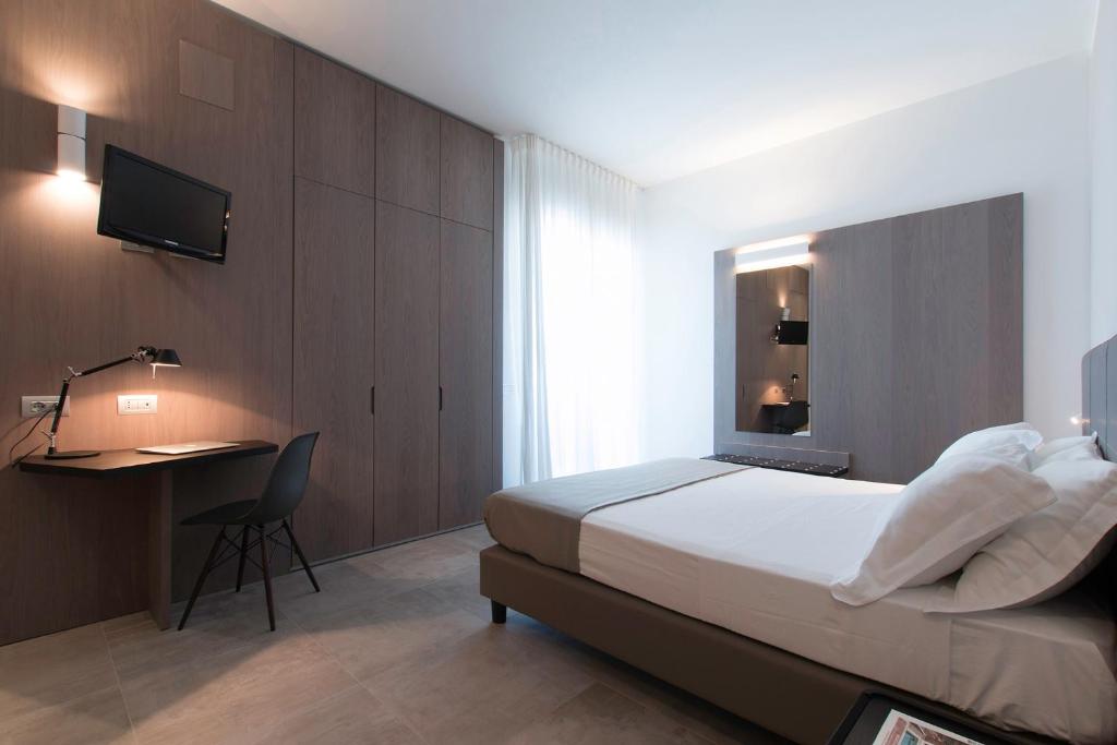 une chambre avec un lit, un bureau et une télévision dans l'établissement Hotel Eden, à Alba Adriatica
