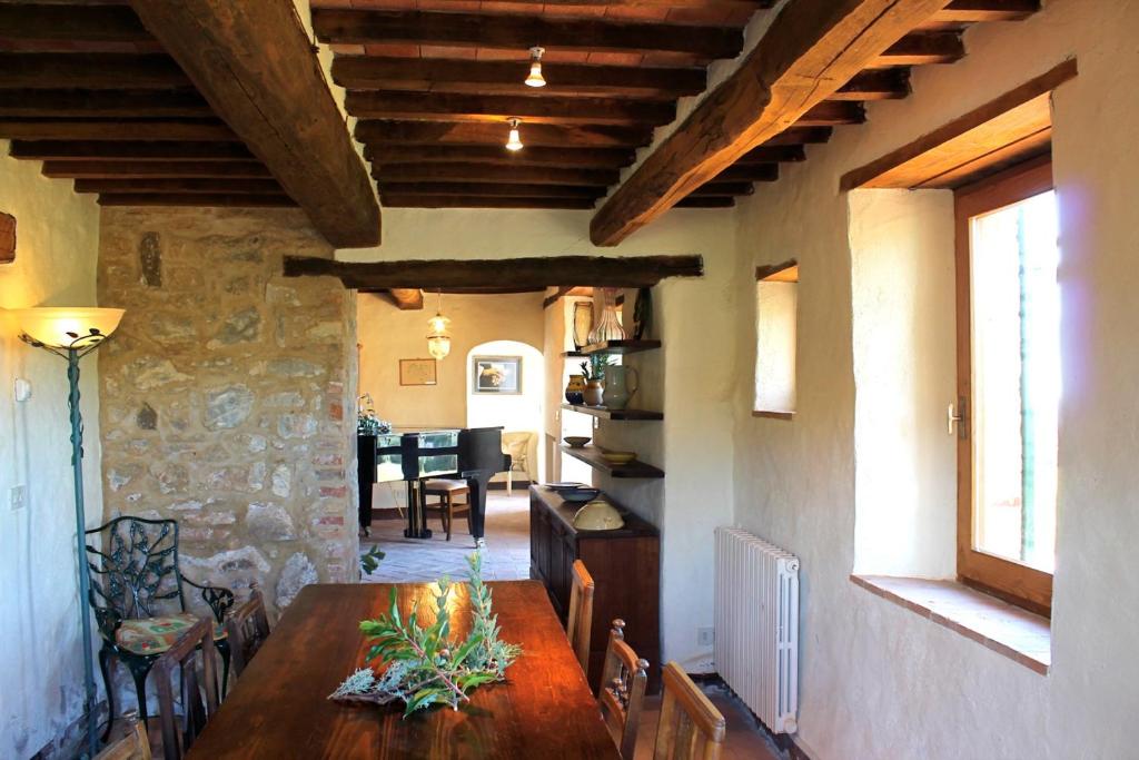une salle à manger avec une table et un mur en pierre dans l'établissement Scansano Country House, à Magliano in Toscana