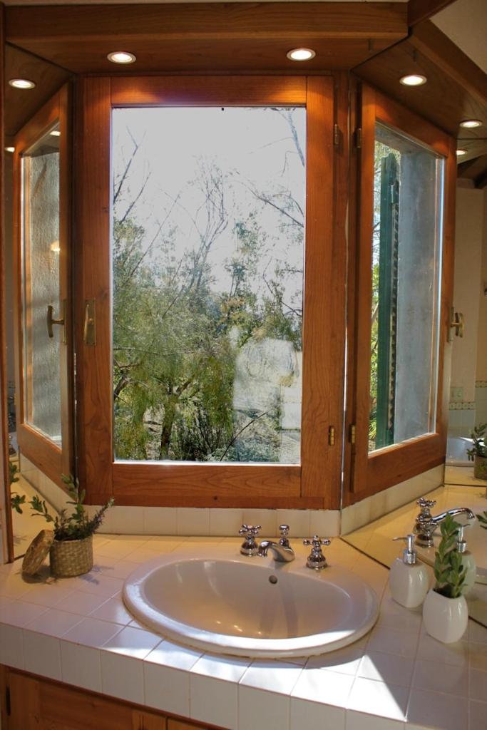 une salle de bain avec un lavabo et une grande fenêtre dans l'établissement Scansano Country House, à Magliano in Toscana