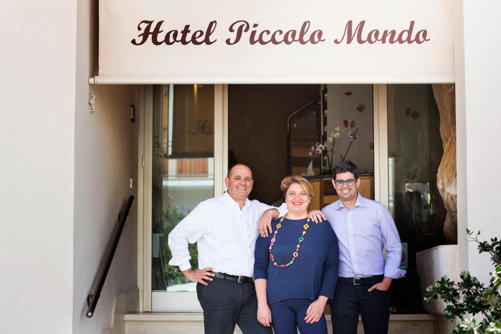 un groupe de trois personnes debout devant un magasin dans l'établissement Hotel Piccolo Mondo, à San Vito Lo Capo