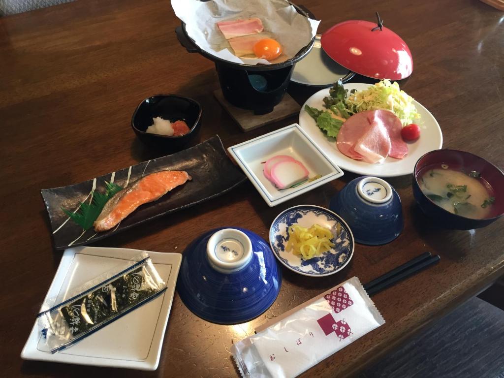 une table en bois avec des assiettes de nourriture dessus dans l'établissement Tokiwa Ryokan, à Nikkō