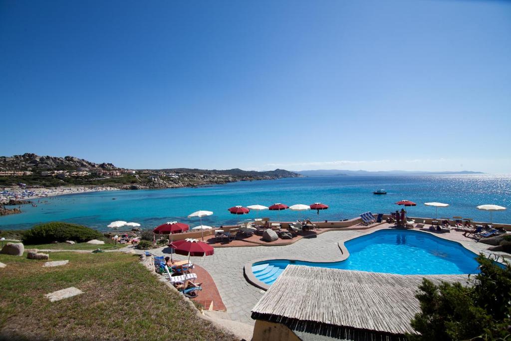 un complexe avec une piscine et une plage avec parasols dans l'établissement Club Esse Shardana, à Santa Teresa Gallura