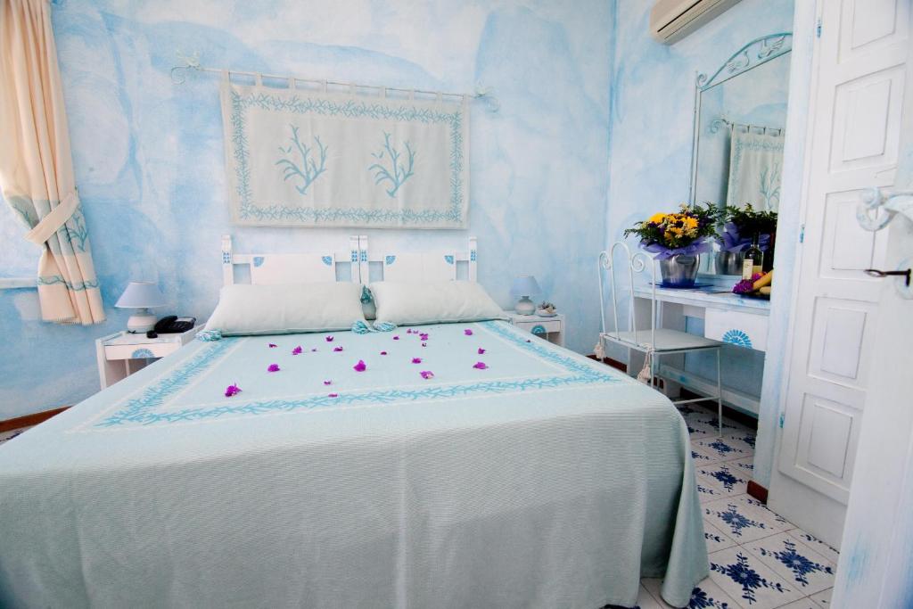une chambre avec un lit blanc avec des fleurs dessus dans l'établissement Club Esse Shardana, à Santa Teresa Gallura