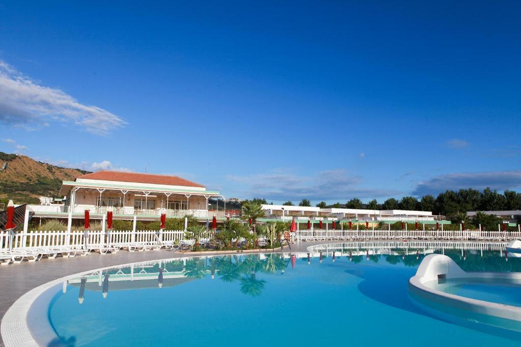 une grande piscine devant un complexe hôtelier dans l'établissement Club Esse Sunbeach, à Squillace