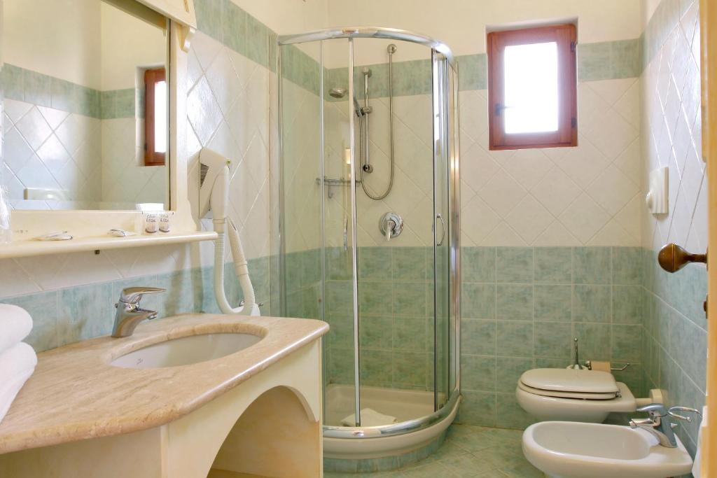 une salle de bain avec douche, lavabo et toilettes dans l'établissement Club Esse Posada, à Palau