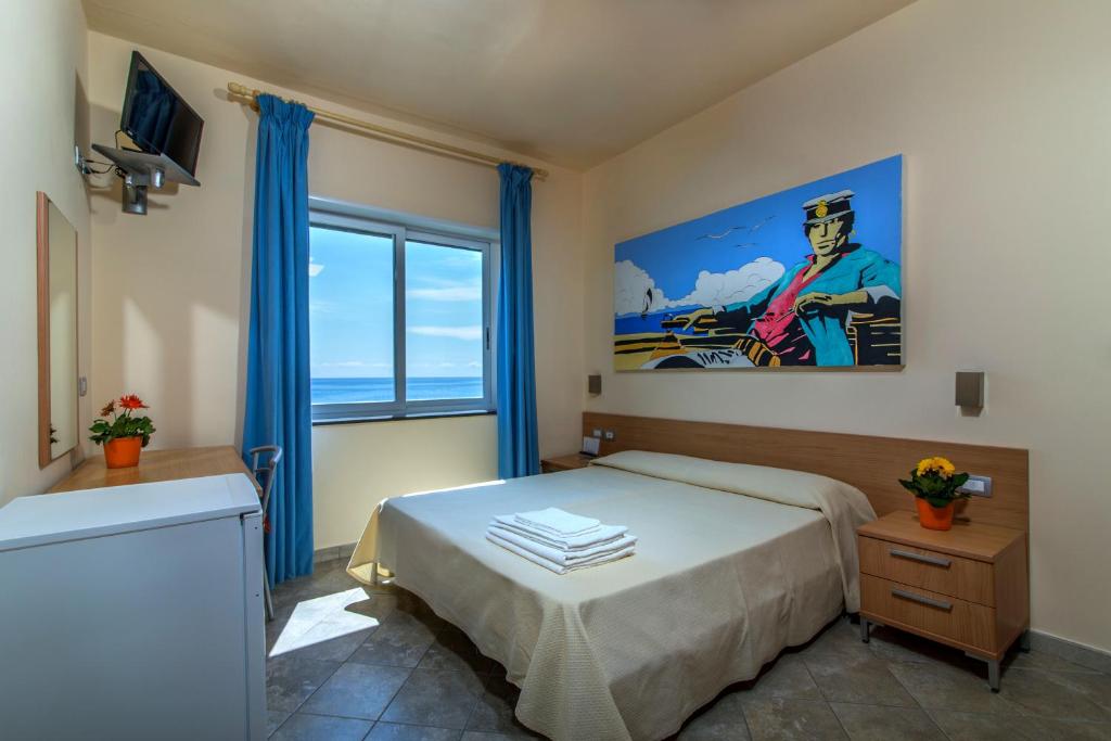 une chambre avec un lit et une grande fenêtre dans l'établissement Villa Comics, à Villammare