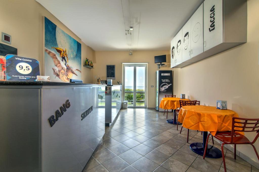 un restaurant avec une table et des chaises dans une salle dans l'établissement Villa Comics, à Villammare