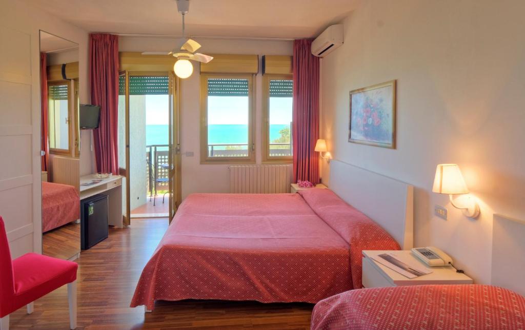 une chambre d'hôtel avec deux lits et une fenêtre dans l'établissement Hotel Eden Gigli, à Numana