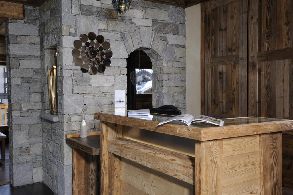 Cette chambre en pierre dispose d'un comptoir en bois avec des livres. dans l'établissement CGH Résidences & Spas Le Jhana, à Tignes