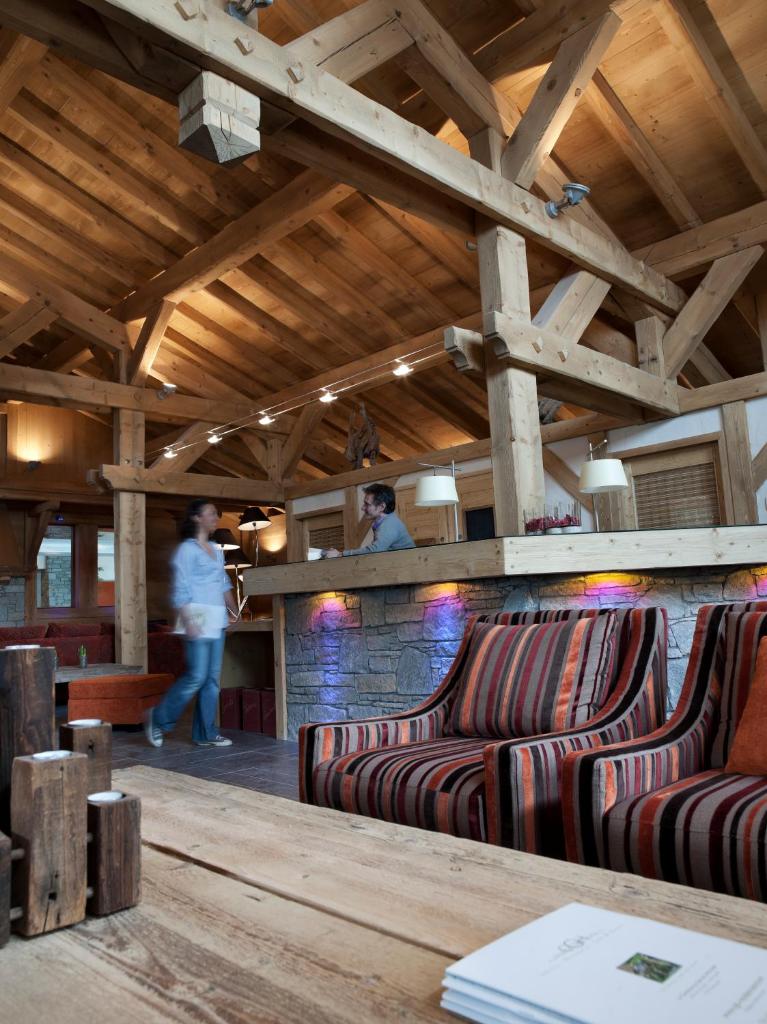 une chambre avec deux canapés et un bar dans l'établissement CGH Résidences & Spas Les Chalets de Jouvence, aux Carroz d'Arâches