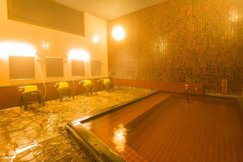 - une grande piscine dans une pièce avec des chaises dans l'établissement Yugawara-Onsen Komachikan, à Yugawara