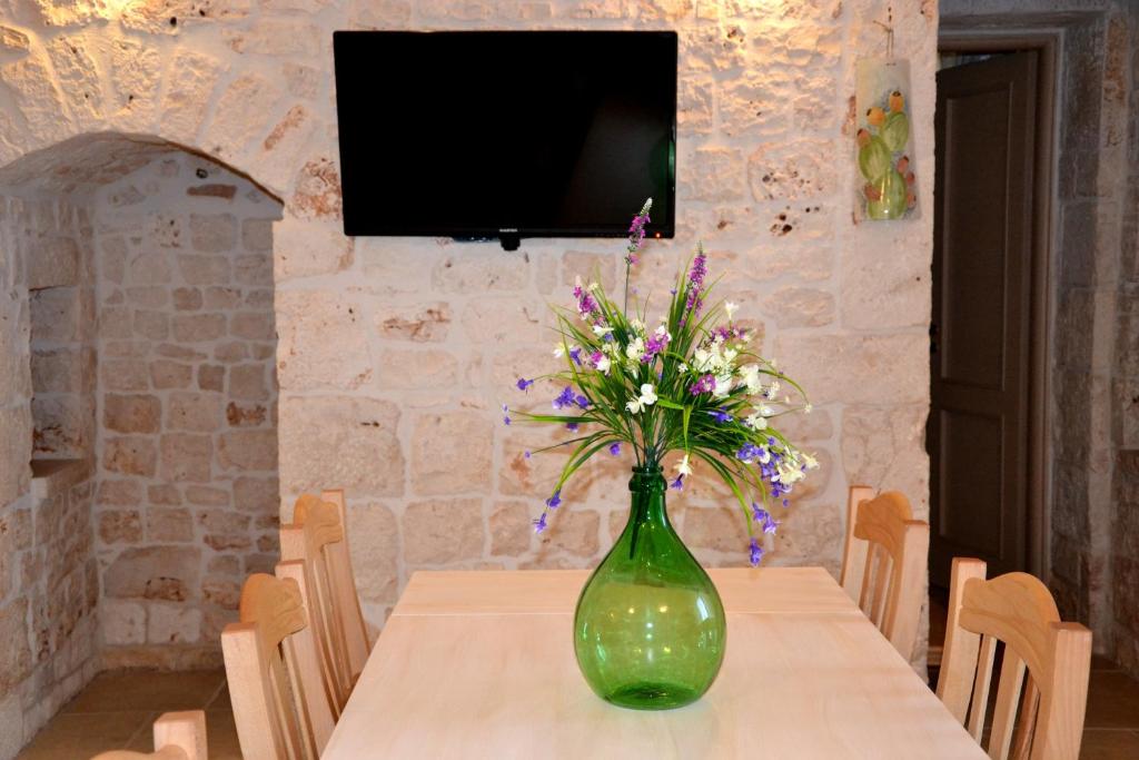 un vase vert avec des fleurs assis sur une table dans l'établissement Casale del Gelso, à Monopoli