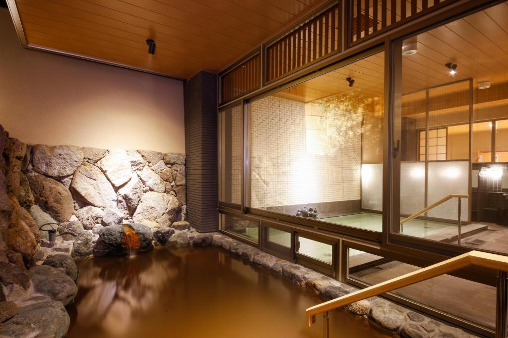 une maison avec un étang au milieu dans l'établissement Okuno Hosomichi, à Kobe