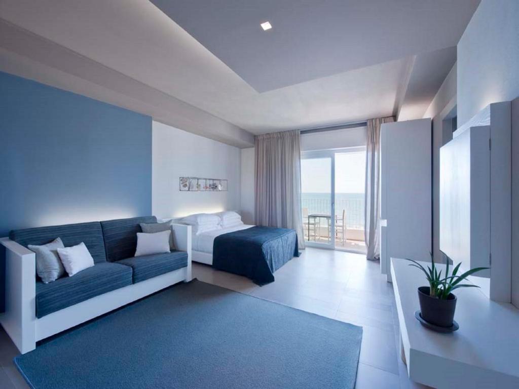 Cette chambre dispose d'un canapé, d'un lit et d'une fenêtre. dans l'établissement Il Fogliano Hotel New Life, à Latina