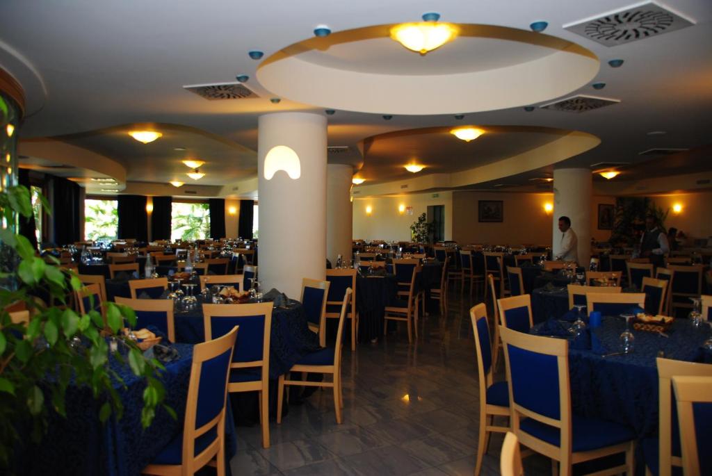 une salle de banquet avec des tables et des chaises dans une pièce dans l'établissement Hotel Scoglio Del Leone, à Zambrone