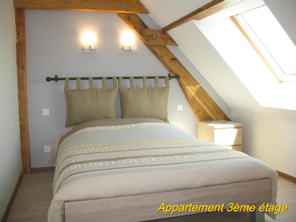 une chambre avec un grand lit dans un grenier dans l'établissement Les Terrasses du Lac Blanc - Studios & Appartements, à Orbey