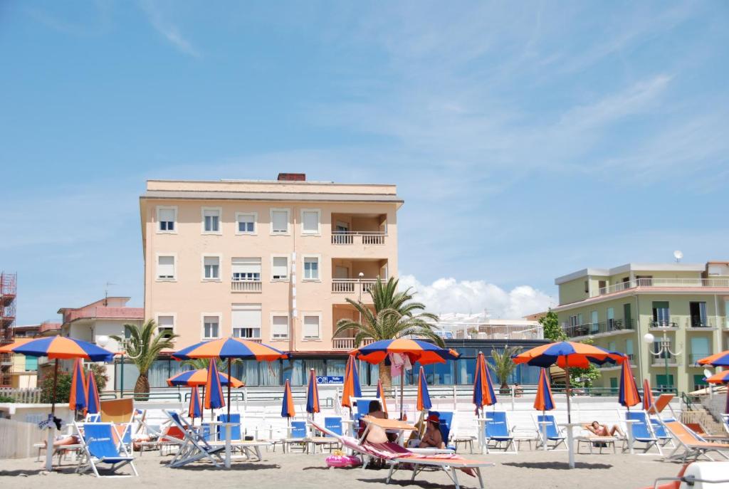 un groupe de chaises et de parasols sur une plage dans l'établissement Hotel Villa Eleonora, à Scauri
