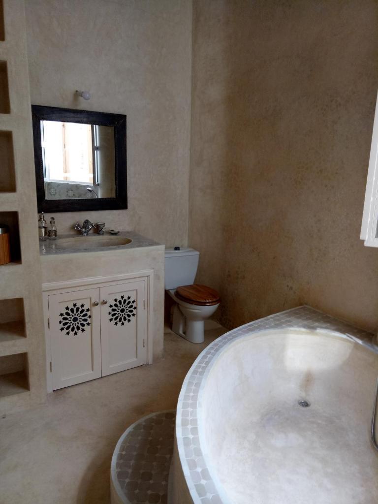 une salle de bain avec une baignoire, des toilettes et un lavabo dans l'établissement Jennat El Mossafir-Riad privé avec services, à Essaouira