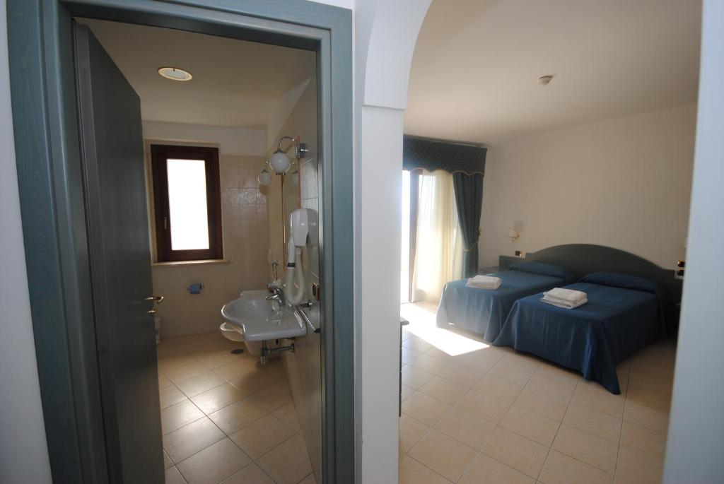 - une vue sur une chambre avec un lit et une salle de bains dans l'établissement Hotel Scoglio Del Leone, à Zambrone